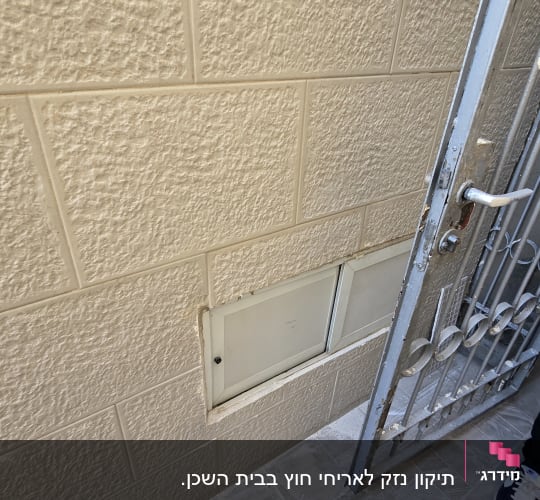 תמונה של קיר עם אריחים ודלת מתכת פתוחה